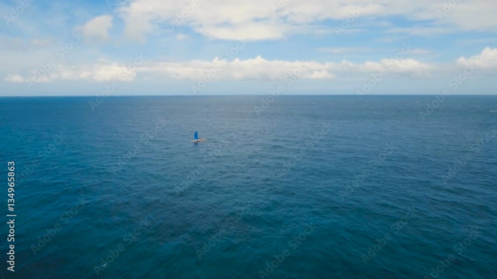 Sailing ship yachts with blue sails in the ocean.Aerial view:Sail boat on sea with cloudy sky. Sailing ship yachts in the sea.Aerial video. Sailing boat in blue sea. Philippines, Boracay. 4K video