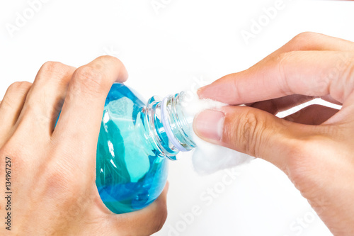man holding ethyl alcohol bottle and cotton ball backgroud photo