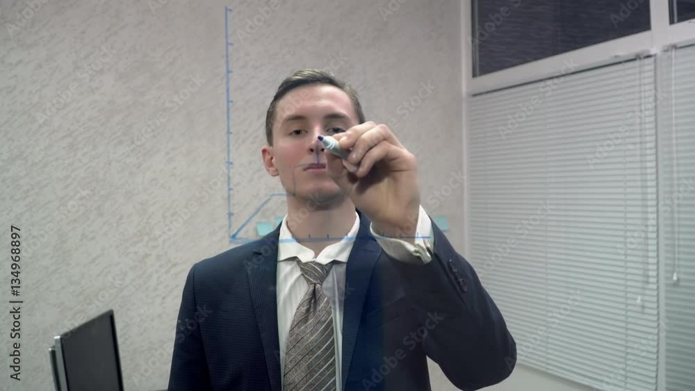 Young office worker drawing on the glass screen in office Young office worker drawing on the glass screen in office