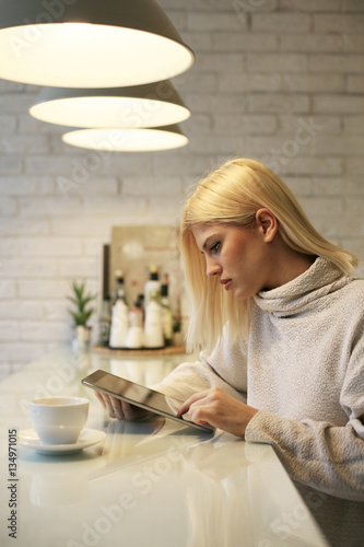 Woman reading news on digital tablet.