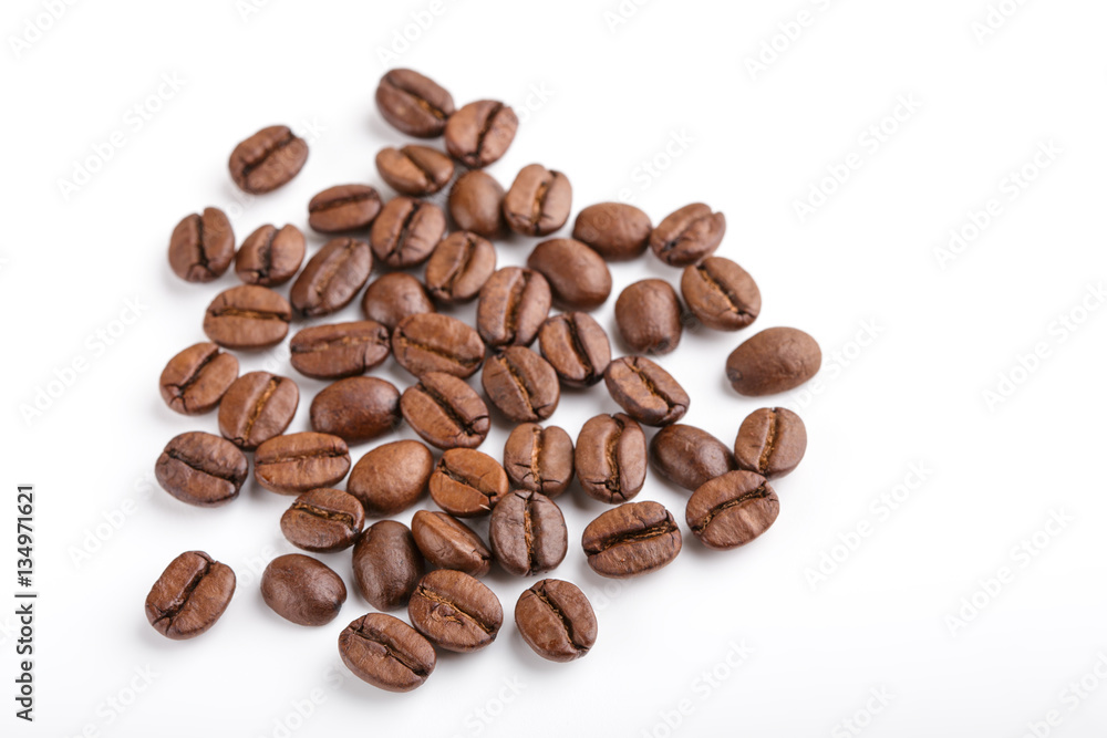 Fototapeta premium roasted coffee beans isolated in white background. Roasted coffee beans background close up. Coffee beans pile from top on white background with copy space for text. Good morning.