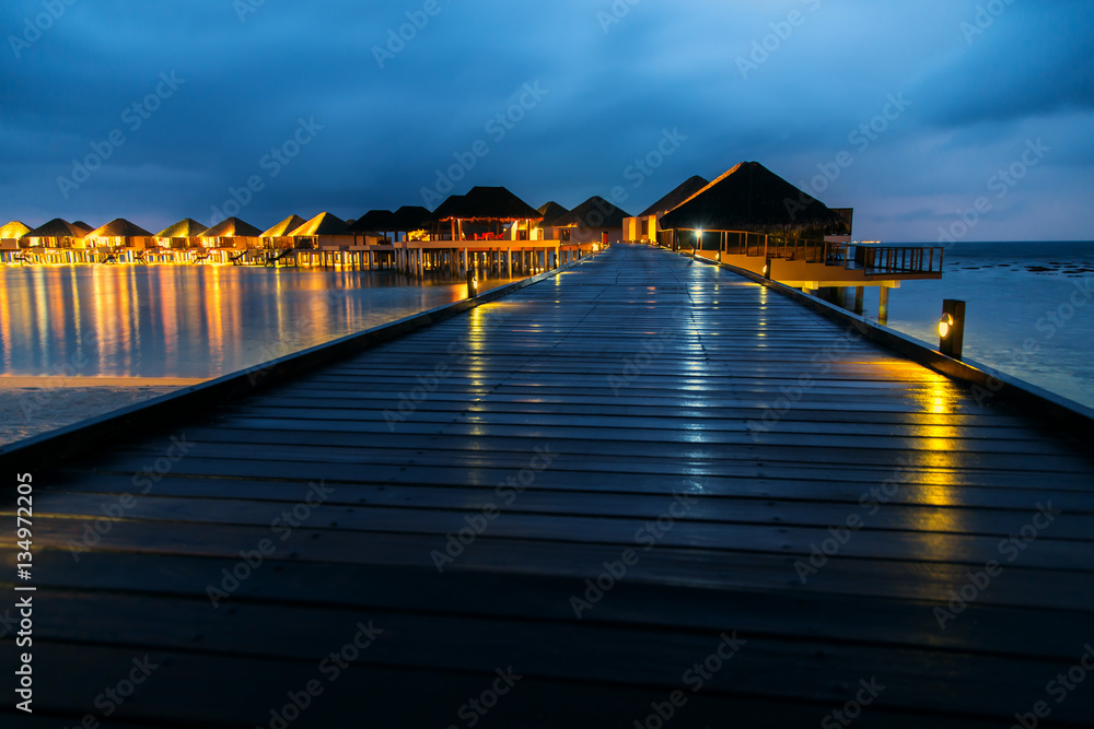 Water bungalows houses at sunset, tropical landscape. Maldives islands