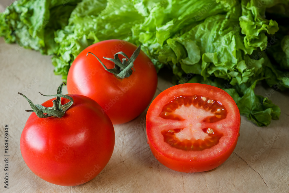 Tomatoes and lettuce on a wooden background. Tomatoes and lettuce on a wooden background.