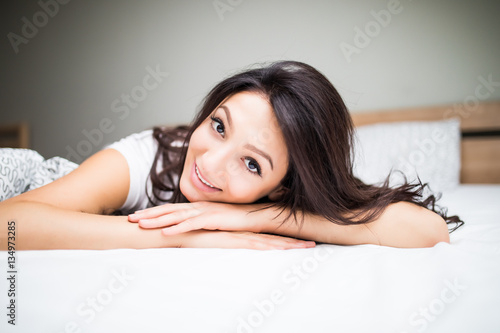 Portrait of beauty woman lying in bed at home