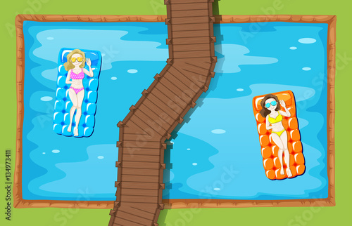 Two women on floating mat in the pool