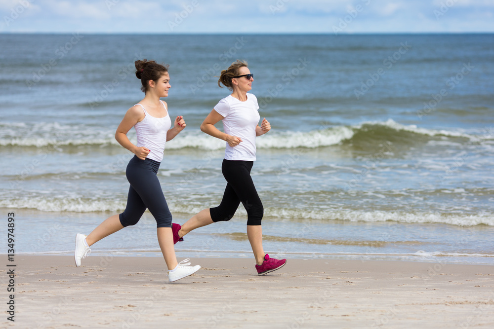 Two women running on beach Two women running on beach