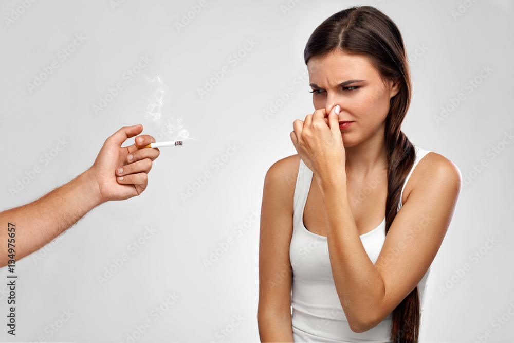 Smoking. Beautiful Woman Holding Nose, Smelling Cigarette Smell Stock