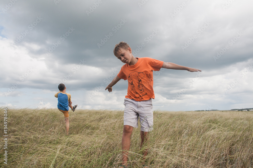 young boys playing in a field. boys in shorts. Boys stand in the desert. feather in the field. boy looking up at the sky. dreamer. two brothers. two friends. children playing in the field.
young boys playing in a field. boys in shorts. Boys stand in the desert. feather in the field. boy looking up at the sky. dreamer. two brothers. two friends. children playing in the field.
