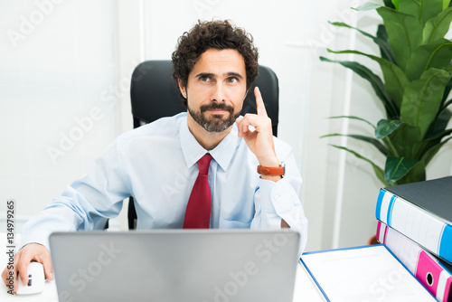 Foto Businessman having an idea while using his computer in the office