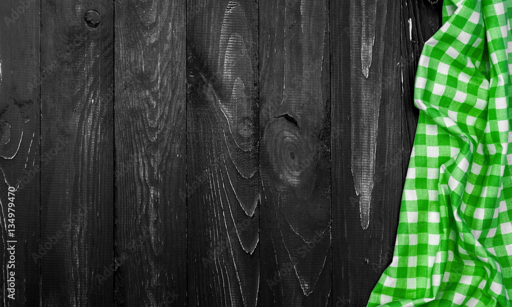 Green checkered tablecloth on a dark background of the old wooden table