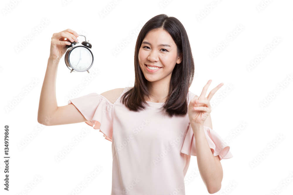 Young Asian business woman show victory sign with a clock. Young Asian business woman show victory sign with a clock.