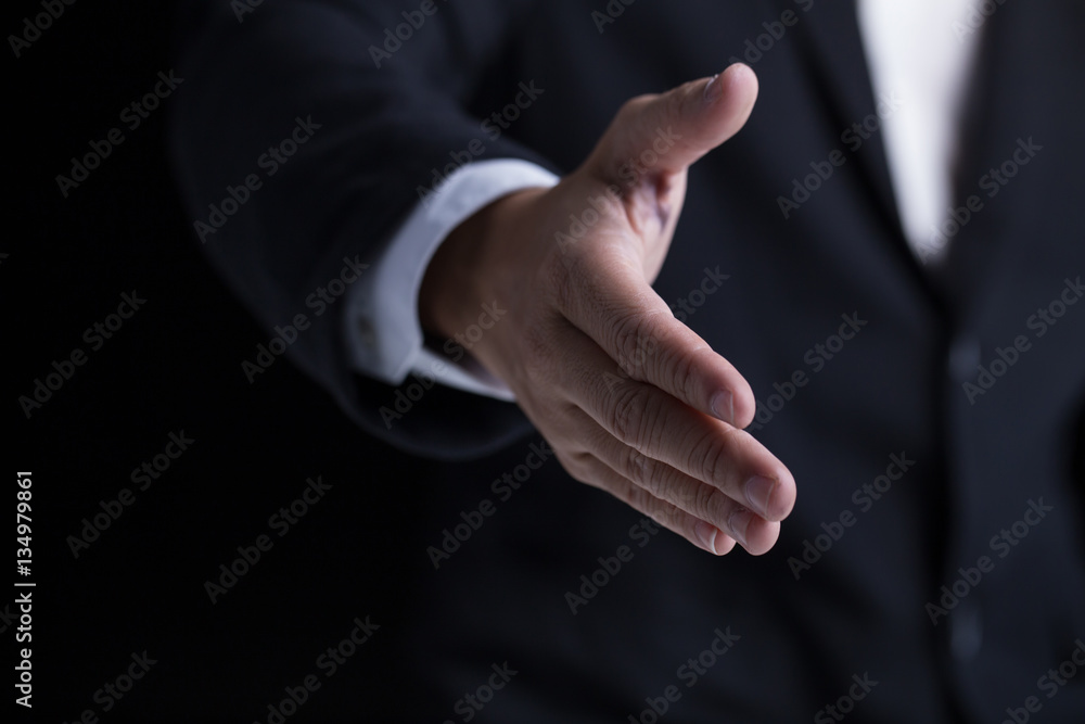 A business man wearing black suit giving one hand for shaking in cooperate look.