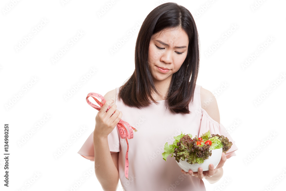 Unhappy Asian business woman with measuring tape and salad. Unhappy Asian business woman with measuring tape and salad.