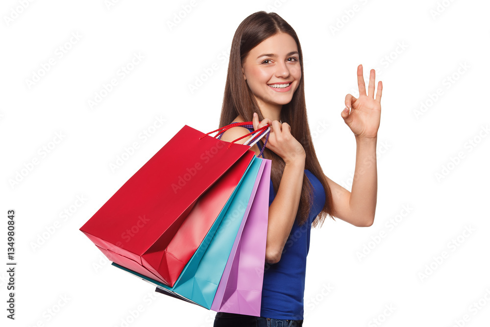 Smile beautiful happy woman holding shopping bags and showing okay sign, isolated on white background Smile beautiful happy woman holding shopping bags and showing okay sign, isolated on white background