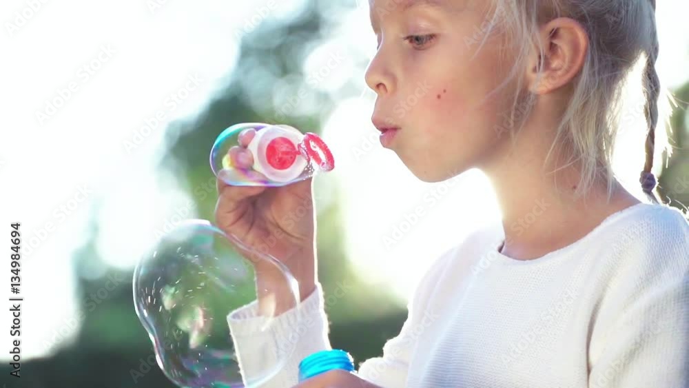 Little girl with a soap bubles in summer Little girl with a soap bubles in summer