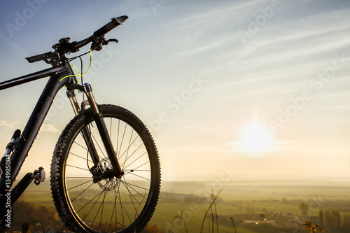 Bicycle silhouettes with sky and sun