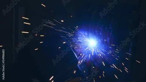 Welding works on a black background and a lot of sparks flying around. Slow motion, high speed camera, 250fps photo