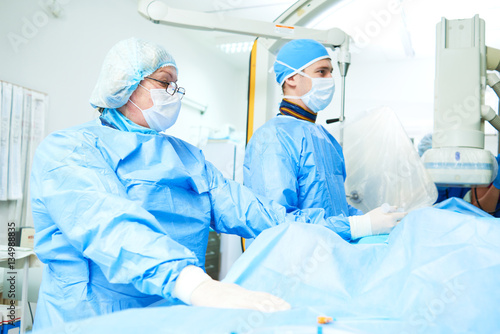 Interventional cardiology. Male surgeon doctor at operation photo