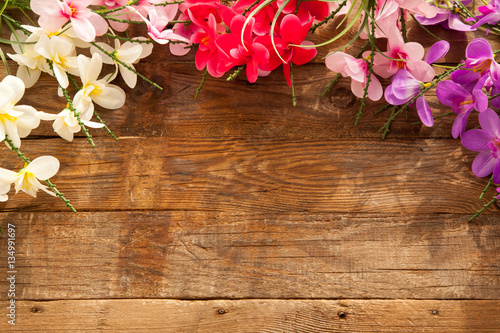 Wooden background with colorful flowers with free space for text. Concept of spring.