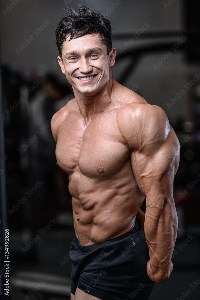 Handsome bodybuilder training in the gym sexy man lift dumbbells Handsome bodybuilder training in the gym sexy man lift dumbbells