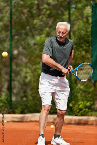 Senior man on tennis court © Microgen