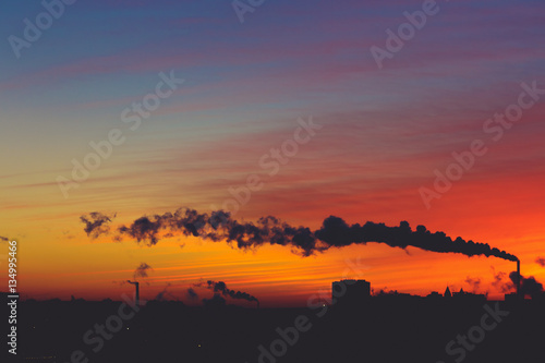 Silhouettes of modern buildings, architecture and smoke from the chimneys © DedMityay