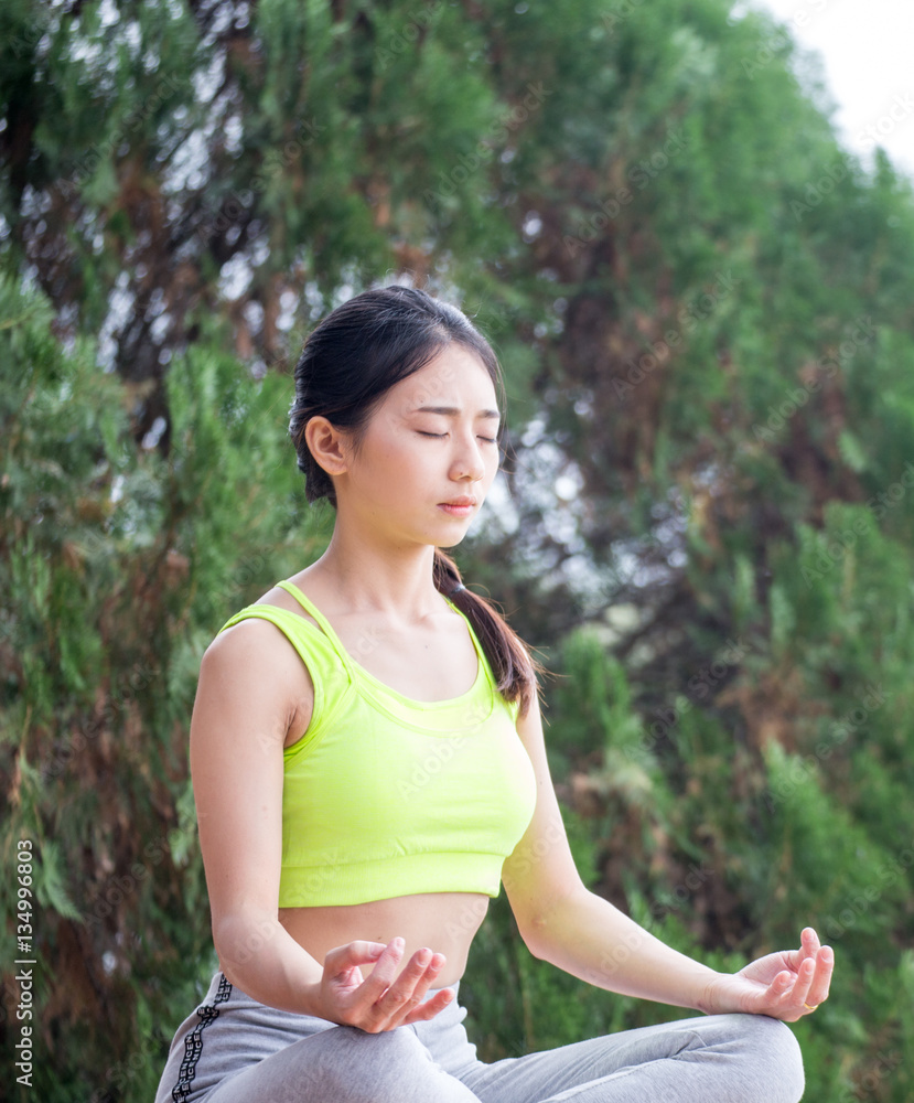 Beautiful young woman sitting in ardha Padmasana Beautiful young woman sitting in ardha Padmasana
