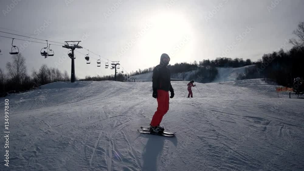 Rear View of Professional Skier Carving Down the Snowy Slope Rear View of Professional Skier Carving Down the Snowy Slope