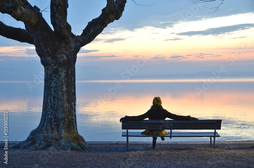 Girl on the bench against lake of Zug, Switzerland photo