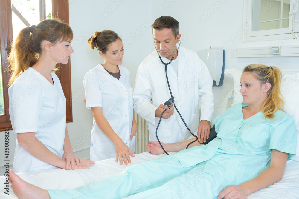 Medical students around patient's hospital bed Medical students around patient's hospital bed