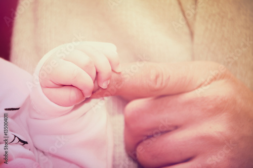 Newborn baby holding mother s hand  image with shallow depth of field