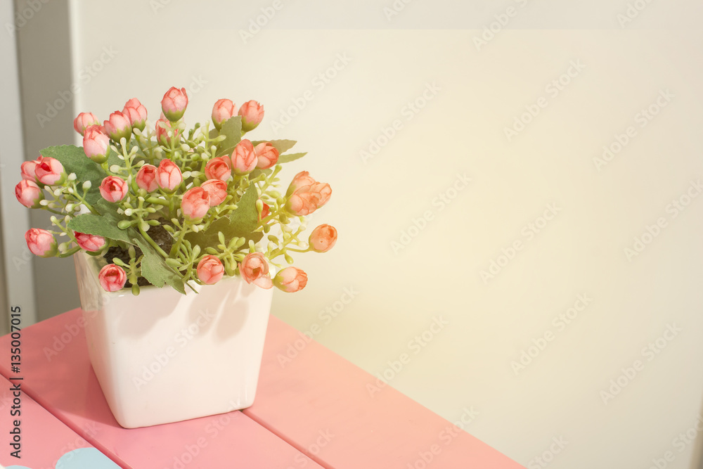 Fototapeta premium Beautiful colors of the flowers in the vase on a wooden table sweet.