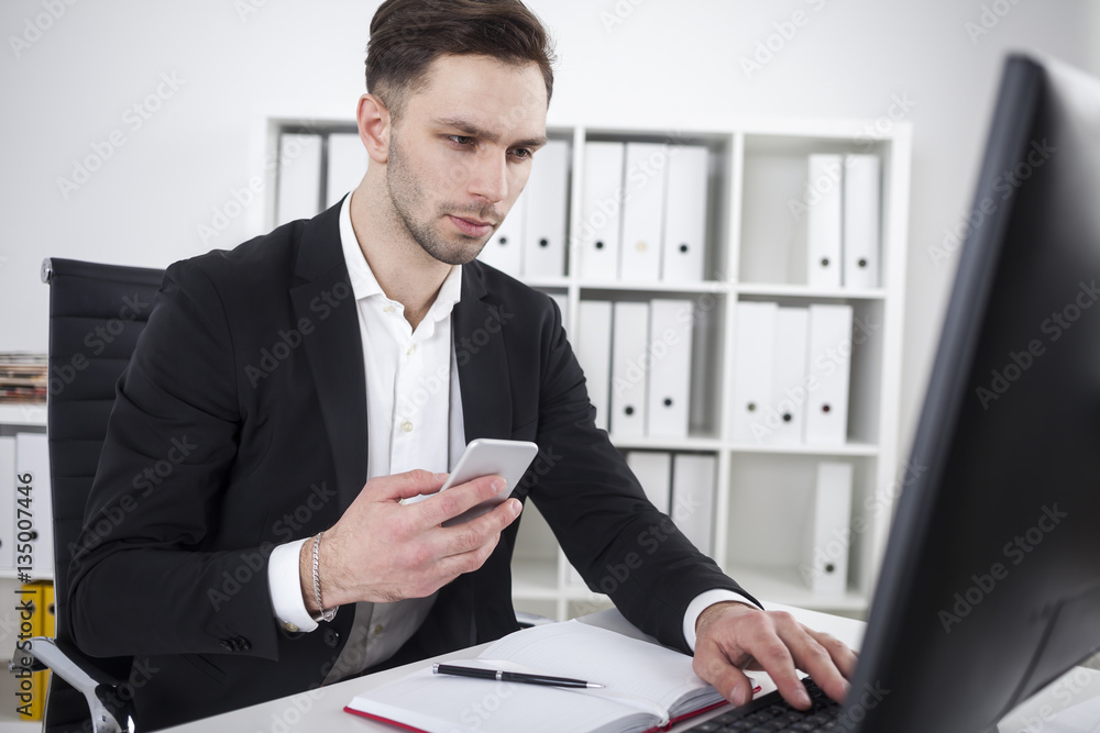 Bearded businessman with phone typing