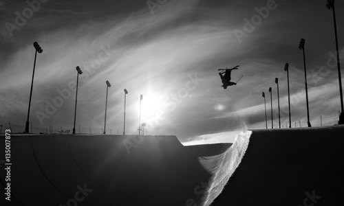 Skier doing an inverted trick in winter snow halfpipe
