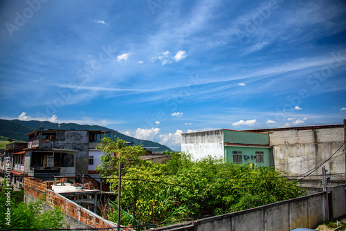 View of houses, mountains and building of brick slums in Bangu neighborhood, where the prison, the Penitentiary Complex of Gericino and Bangu dump are located, the West Zone of Rio de Janeiro, Brazil