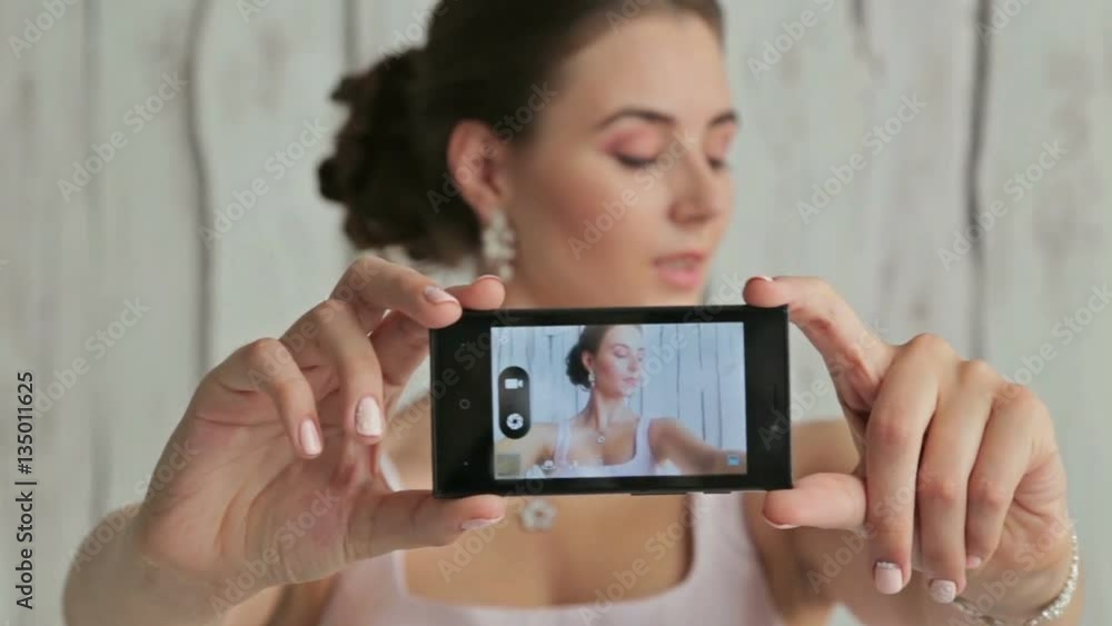 3 shots. Pretty, young and sensual woman with beautiful make-up and elegant hairstyle taking selfie. White wooden background. Beauty, fashion and technology concept 3 shots. Pretty, young and sensual woman with beautiful make-up and elegant hairstyle taking selfie. White wooden background. Beauty, fashion and technology concept