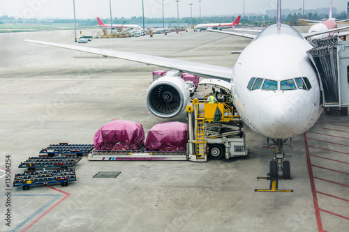 Loading cargo on the plane in airport, view through window photo