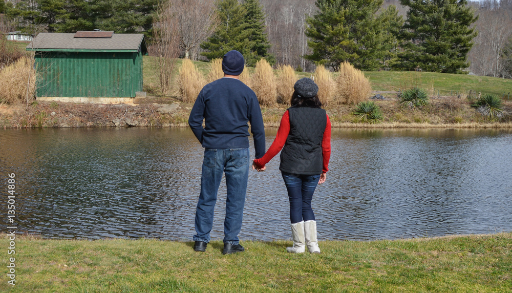 Romantic couple holding hands with lake view