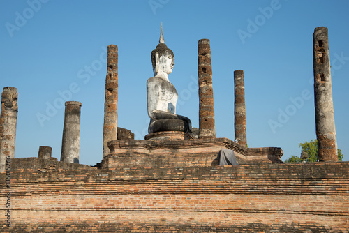 Ancient sculpture of a seated Buddha at the ruins of the Buddhist temple Wat Mahathat. Sukhothai, Thailand