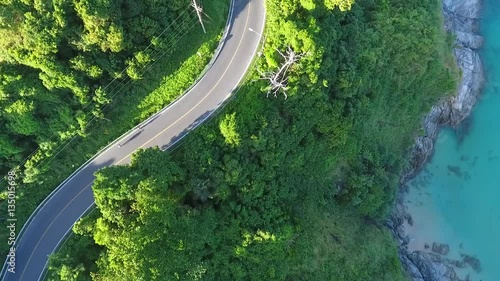 Two athletes come down the mountain on the asphalt road next to the sea. Morning cardio. HD aerial shot. photo