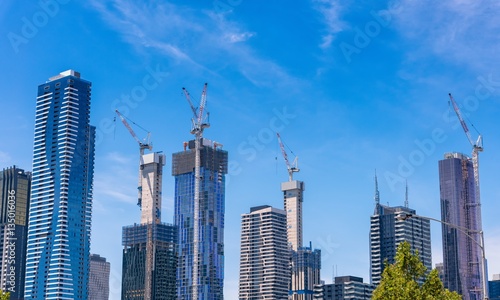 Melbourne, Australia, city skyline with many buildings under construction against a blue sky with light clouds.