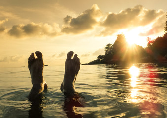 Naked human barefeet at secret beach during sunset in Koh Lipe - Wanderlust travel concept with wonderful South East Asia destination in Thailand - Soft detailed focus for backlight waterproof camera