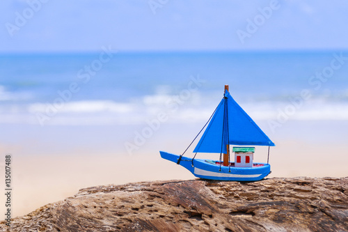 Miniature toy sailboat on the beach