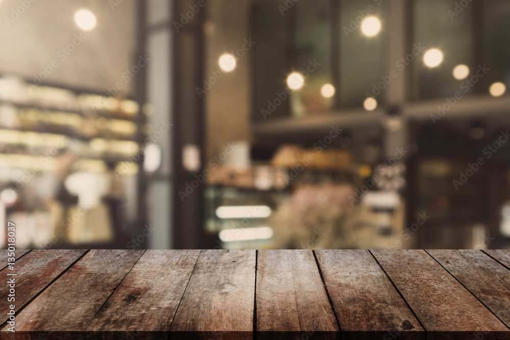 Wood table top and blurred bokeh cafe and coffee shop interior