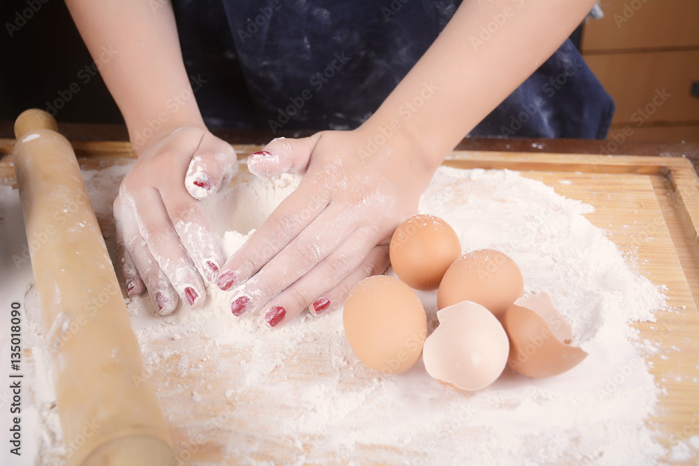 Woman hands knead dough.