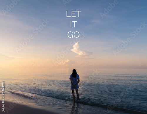 Fotografie Inspirational quote on silhouette of woman walking on the beach