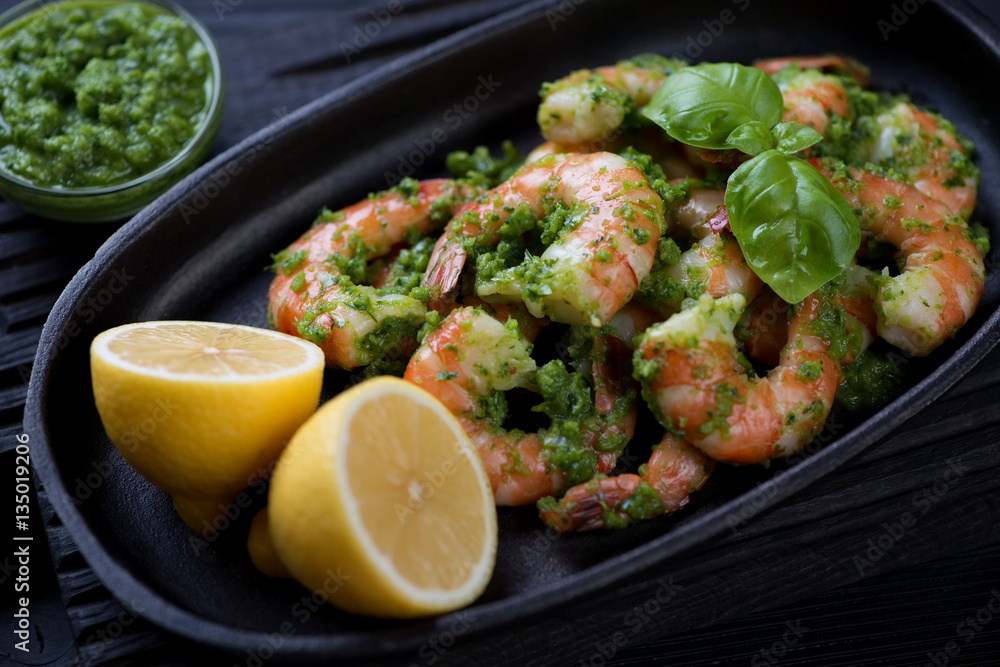 Close-up of tiger shrimps with parsley sauce in a frying pan