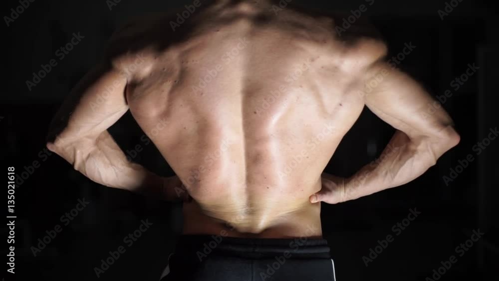 Muscular bodybuilder handsome men doing exercises in gym naked torso Muscular bodybuilder handsome men doing exercises in gym naked torso