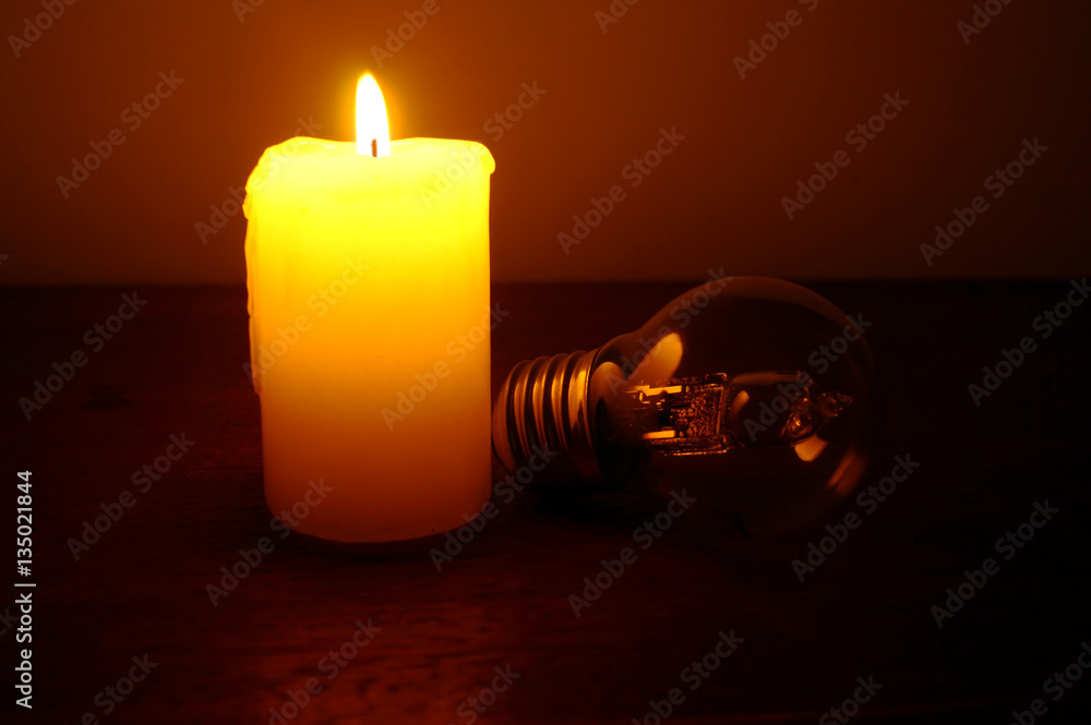 Burning candle and lamp on desktop. Power outage. Missing electricity - blackout begin.
