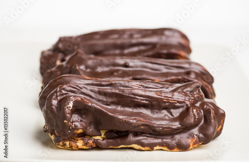 Chocolate eclair on the white table. Shallow depth of field.